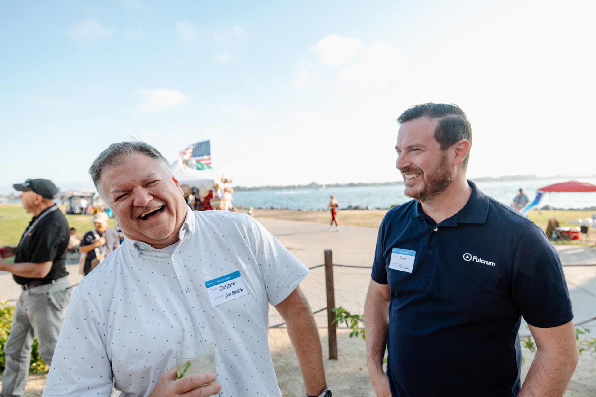 Two attendees laughing at an Energy Central waterfront event